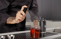 spray valencia orange spray onto a drink in a rocks gloss 